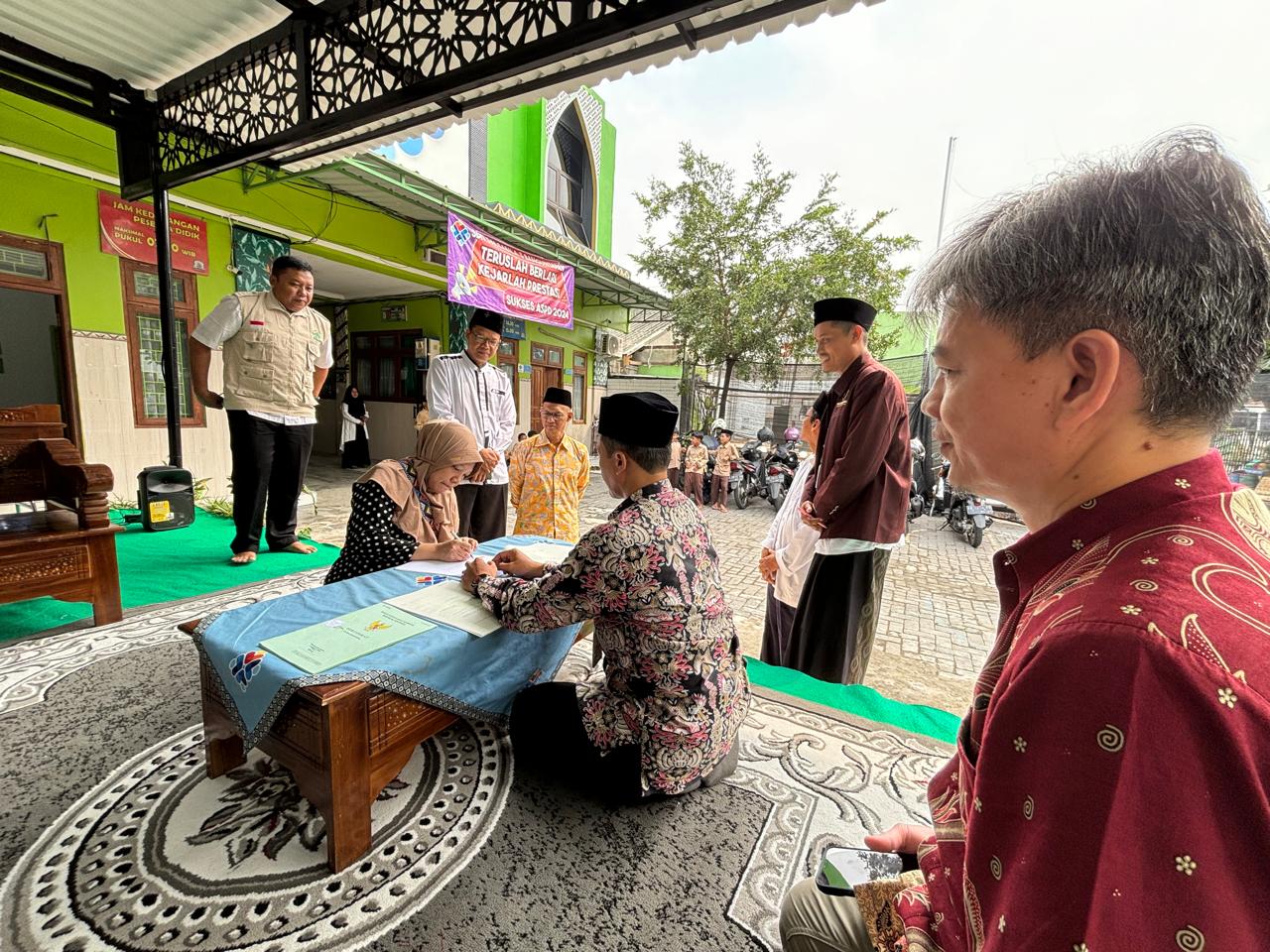 Pendanatanganan dokumen wakaf di depan kedua bidang tanah yang diwakafkan